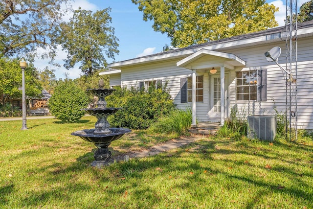 view of front of property featuring cooling unit and a front yard