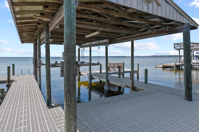 dock area with a water view and boat lift