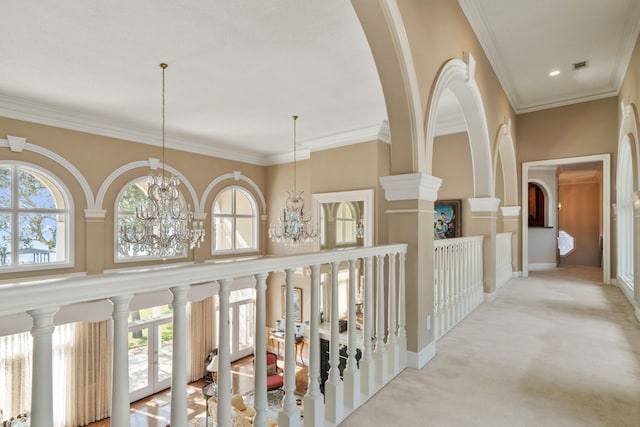 corridor featuring a chandelier, carpet flooring, visible vents, and crown molding