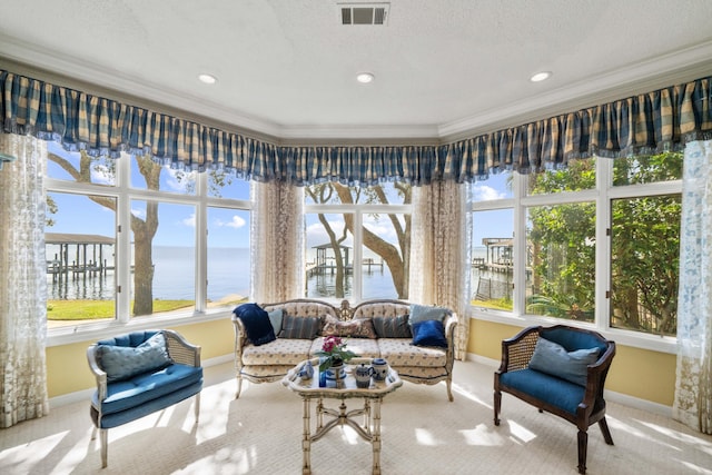 sunroom / solarium with visible vents and a water view