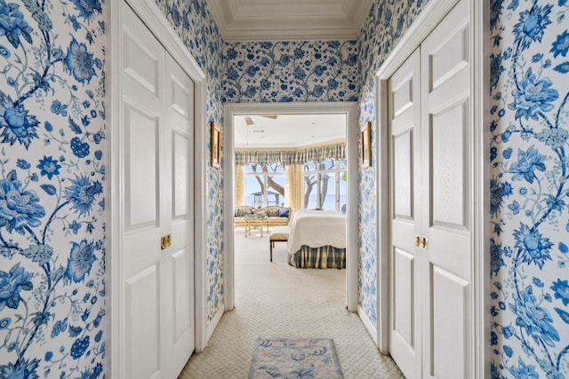 hallway with light carpet, wallpapered walls, and ornamental molding