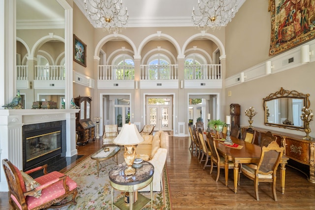 living room with a fireplace, ornamental molding, a notable chandelier, and wood finished floors