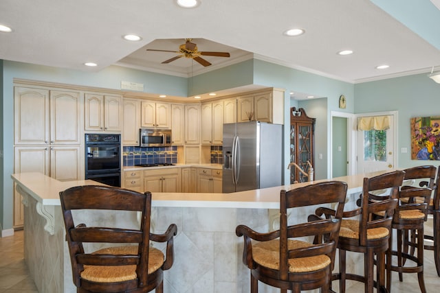 kitchen featuring light tile patterned floors, a breakfast bar area, stainless steel appliances, ornamental molding, and decorative backsplash