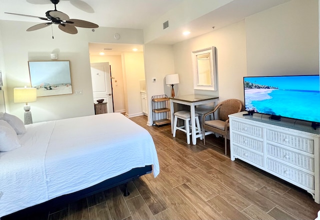 bedroom featuring ceiling fan, hardwood / wood-style flooring, and ensuite bath