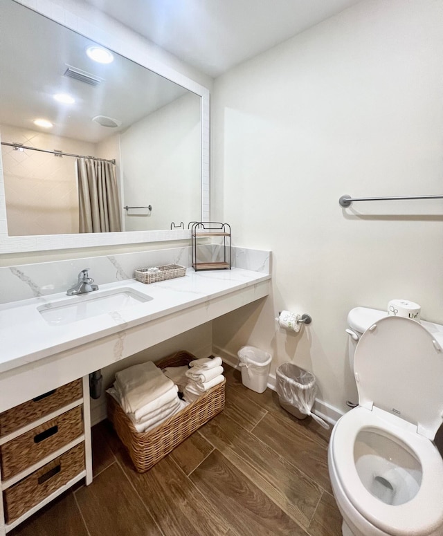 bathroom featuring curtained shower, vanity, toilet, and hardwood / wood-style flooring