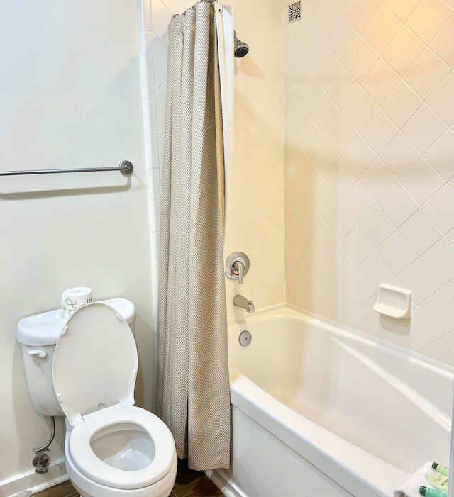 bathroom featuring shower / tub combo and toilet