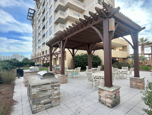 view of patio featuring area for grilling, a balcony, and exterior bar