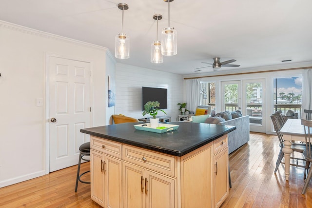 kitchen with a kitchen breakfast bar, light hardwood / wood-style flooring, hanging light fixtures, and a kitchen island