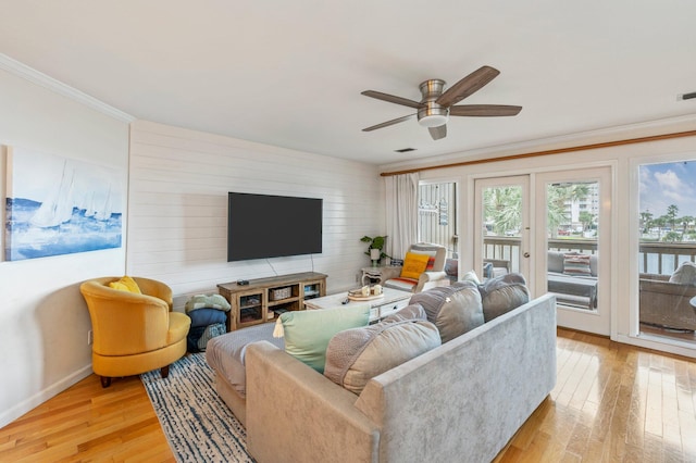 living room with ceiling fan, ornamental molding, and light hardwood / wood-style flooring