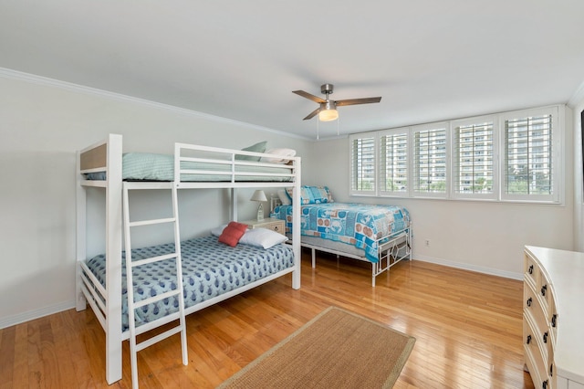 bedroom featuring ornamental molding, wood-type flooring, and ceiling fan