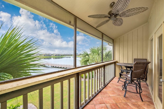 balcony featuring a water view and ceiling fan