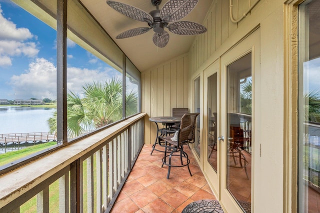 balcony with a water view and ceiling fan