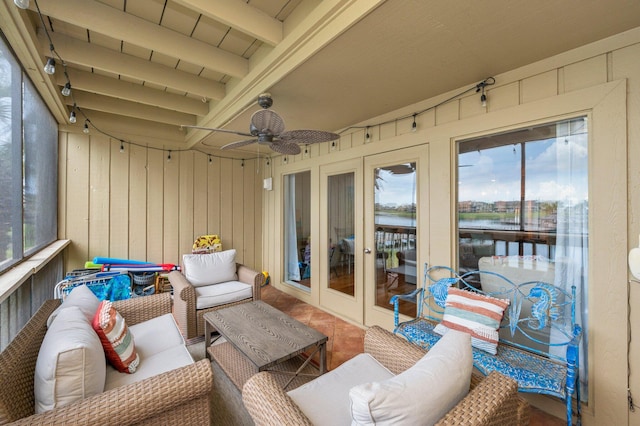 sunroom featuring beam ceiling and ceiling fan