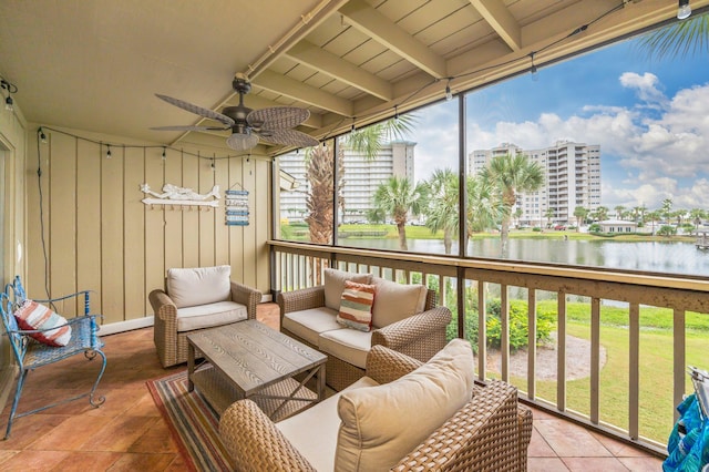 sunroom featuring beamed ceiling, wood ceiling, a water view, and ceiling fan