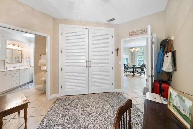 interior space with a notable chandelier, a closet, and connected bathroom