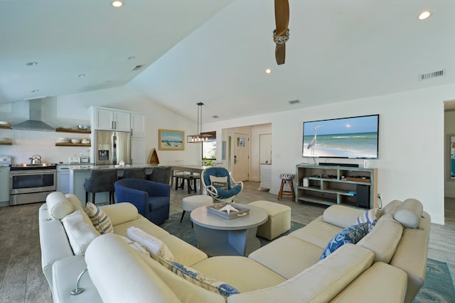 living room featuring hardwood / wood-style floors, ceiling fan, and vaulted ceiling