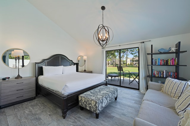 bedroom featuring high vaulted ceiling, hardwood / wood-style floors, an inviting chandelier, and access to outside