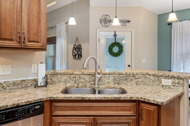 kitchen with light stone countertops, stainless steel dishwasher, decorative light fixtures, and sink