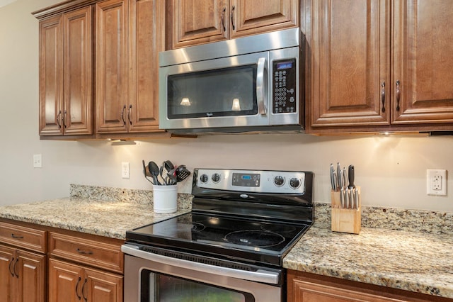 kitchen featuring light stone countertops and stainless steel appliances