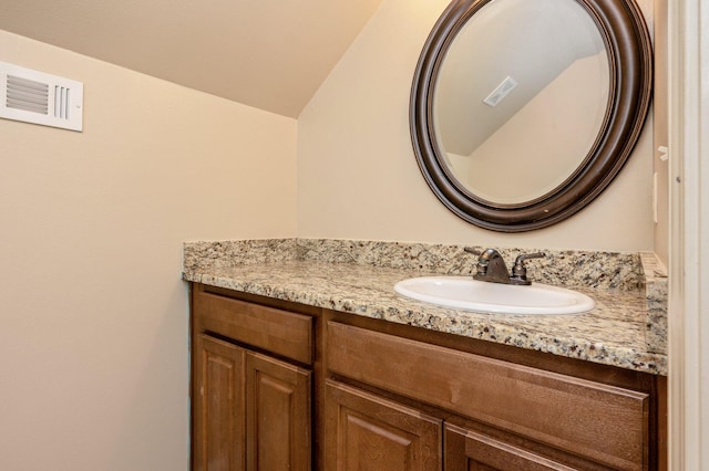 bathroom featuring lofted ceiling and vanity