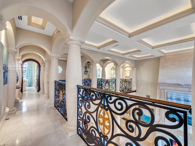 hallway featuring coffered ceiling, beam ceiling, light tile patterned floors, and decorative columns