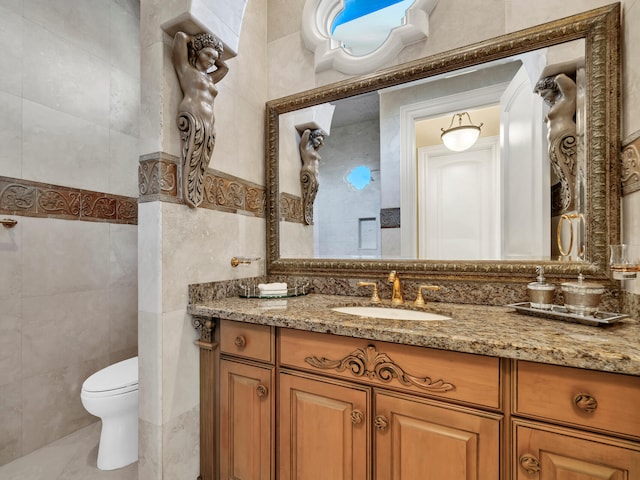 bathroom featuring vanity, toilet, and tile walls