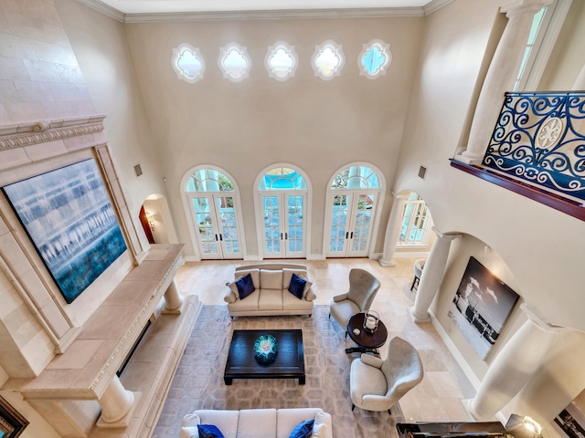 living room with french doors, a towering ceiling, and ornamental molding