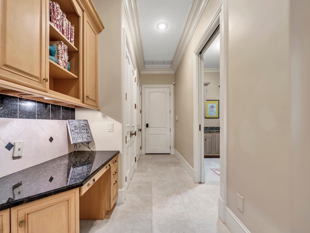 interior space featuring light brown cabinetry, ornamental molding, backsplash, and light tile patterned floors