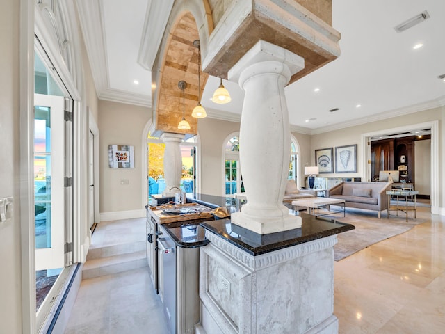 kitchen with decorative light fixtures, a center island, crown molding, and decorative columns