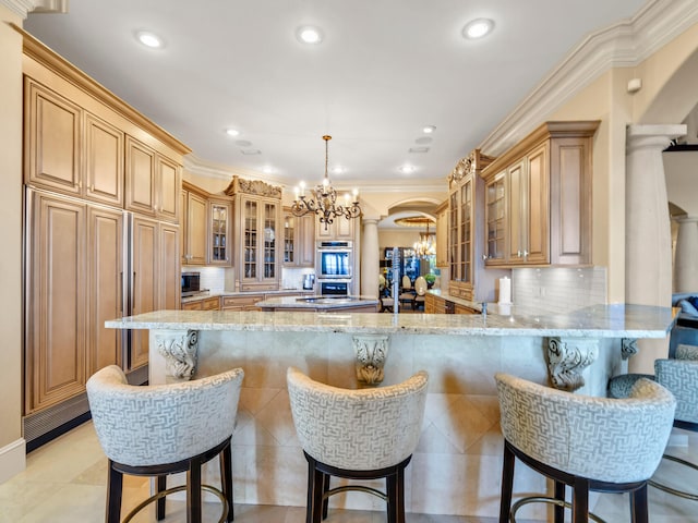 kitchen with kitchen peninsula, a kitchen bar, decorative columns, and hanging light fixtures