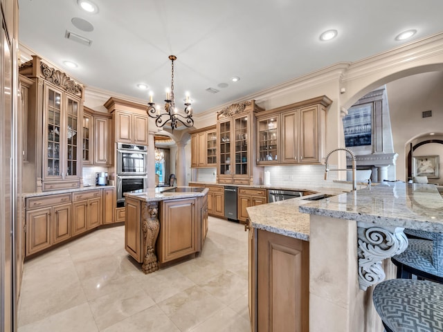 kitchen featuring decorative backsplash, appliances with stainless steel finishes, decorative light fixtures, a kitchen island, and kitchen peninsula