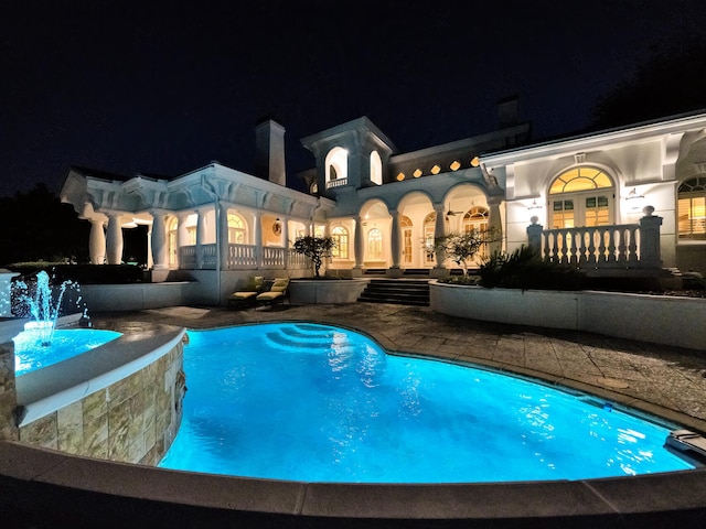 pool at night with pool water feature