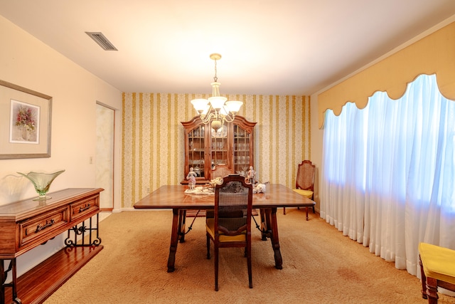 carpeted dining room featuring a chandelier