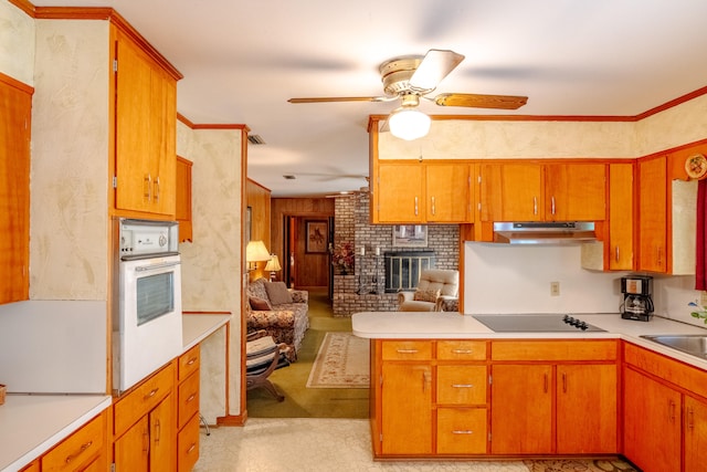 kitchen featuring white oven, kitchen peninsula, a fireplace, black electric cooktop, and ceiling fan