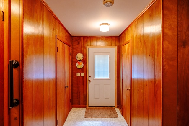 doorway to outside featuring wooden walls