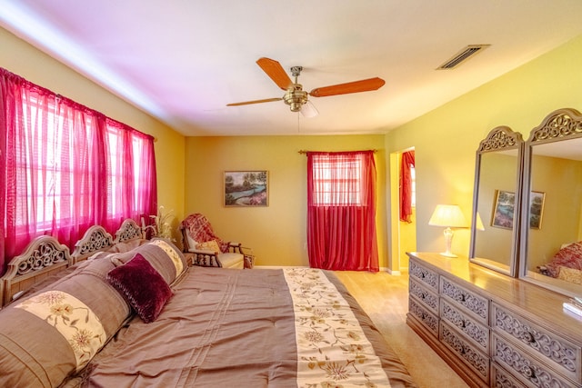 carpeted bedroom with multiple windows and ceiling fan