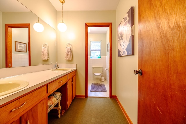 bathroom with vanity, tile walls, and toilet