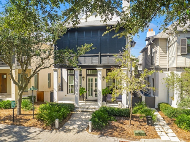 view of front of property featuring a balcony and french doors