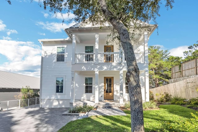 neoclassical home featuring a front yard and a balcony