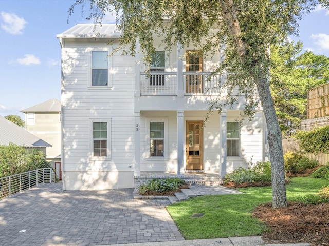 view of front of property with a balcony and a front lawn