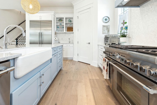 kitchen with white cabinetry, light hardwood / wood-style floors, pendant lighting, range hood, and high end appliances