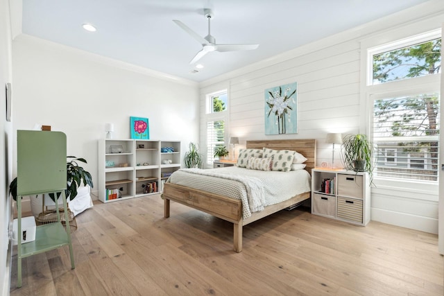 bedroom featuring ornamental molding, light wood-type flooring, and ceiling fan