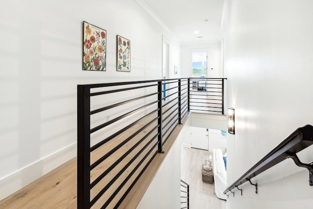 stairway featuring ornamental molding and hardwood / wood-style floors