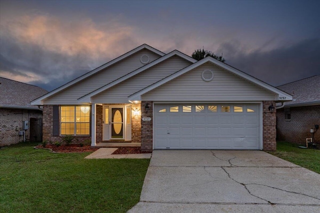 view of front of home with a garage and a yard