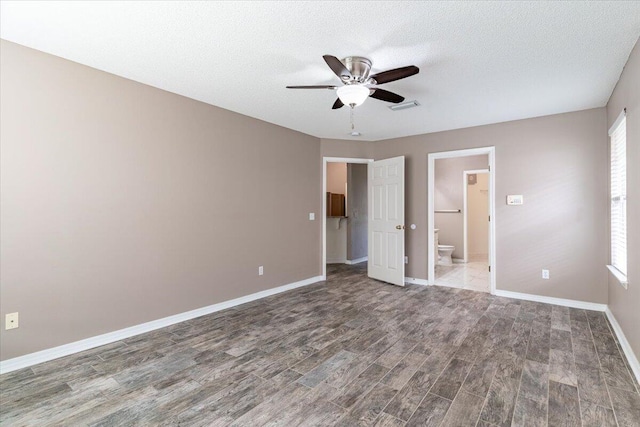 unfurnished bedroom with hardwood / wood-style floors, ensuite bathroom, a textured ceiling, and ceiling fan