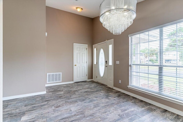 foyer entrance featuring wood-type flooring and an inviting chandelier