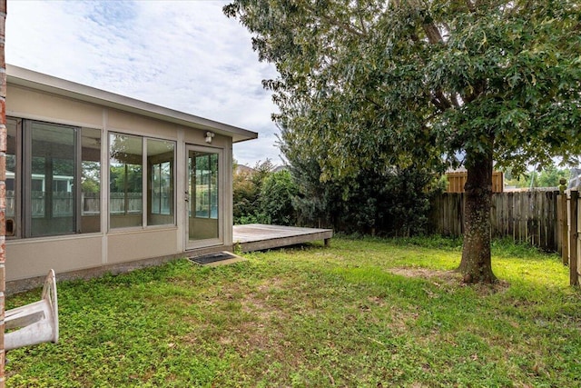 view of yard with a sunroom and a wooden deck