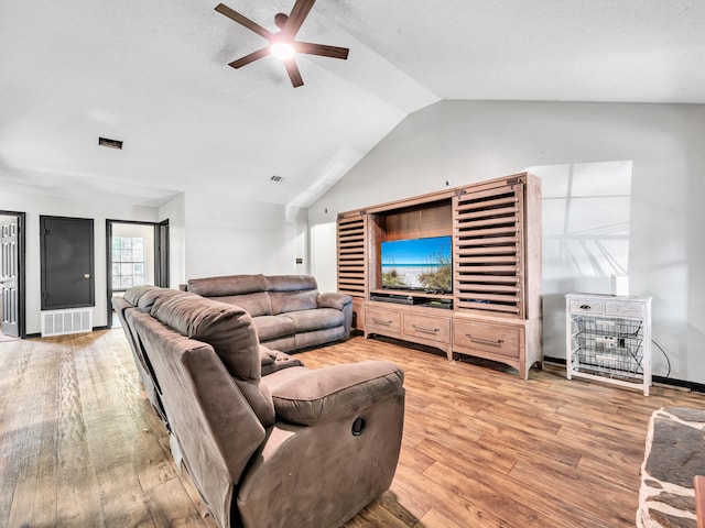 living room with hardwood / wood-style floors, ceiling fan, and vaulted ceiling