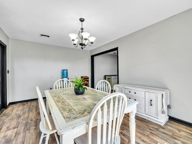 dining room with a chandelier and hardwood / wood-style flooring