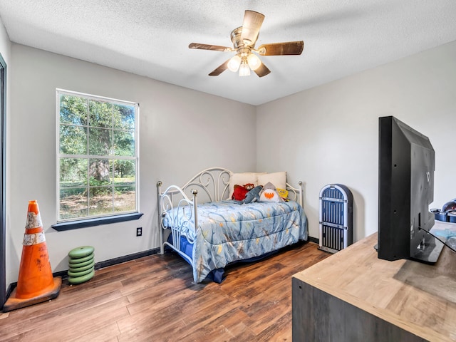 bedroom featuring dark hardwood / wood-style flooring, a textured ceiling, and ceiling fan